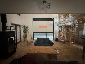 a living room with a couch and a tv at Gîte du Séquoia - Paisible maison de campagne in Vallet