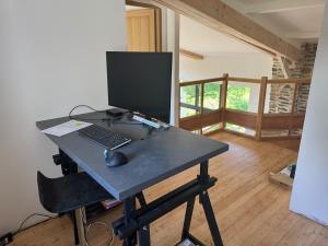 een bureau met een computermonitor en een toetsenbord en muis bij Gîte du Séquoia - Paisible maison de campagne in Vallet