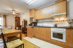 a kitchen with wooden cabinets and a wooden table at Alojamiento Las Guixas Villanua in Villanúa +1 photo