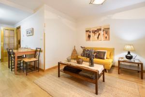 a living room with a yellow couch and a table at Alojamiento Las Guixas Villanua in Villanúa