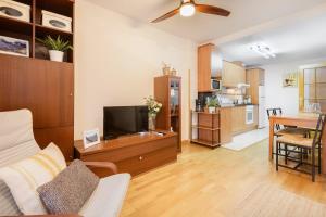 a living room with a television and a dining room at Alojamiento Las Guixas Villanua in Villanúa