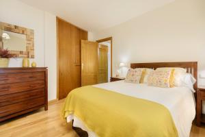 a bedroom with a large bed and a wooden dresser at Alojamiento Las Guixas Villanua in Villanúa