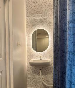 ein Badezimmer mit Waschbecken und Spiegel in der Unterkunft Zephyr Inn Pondy in Puducherry