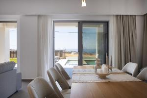 a dining room with a table and chairs with a view at MiNo Mare modern Sea View Villa with Pool up to 12 in Panormos Rethymno