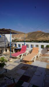 a group of chairs and an umbrella on a patio at Jalila House in Aourir