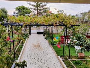 a garden with a pergola with plants at Mia Home in Artemida