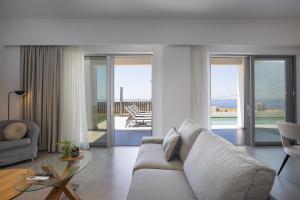a living room with a couch and a glass table at MiNo Mare modern Sea View Villa with Pool up to 12 in Panormos Rethymno
