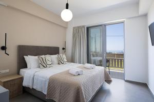a bedroom with a bed with two towels on it at MiNo Mare modern Sea View Villa with Pool up to 12 in Panormos Rethymno +45 photos