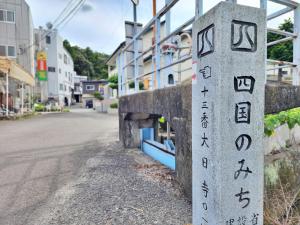 a stone sign on the side of a street at 名西旅館花 in Tokushima