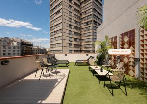een balkon met stoelen en tafels op een gebouw bij Casanova Apartments by Olala Homes in Barcelona