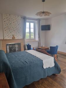 a bedroom with a blue bed and a fireplace at Bel appartement de plein pied avec jardin privé in Moncayolle-Larrory-Mendibieu