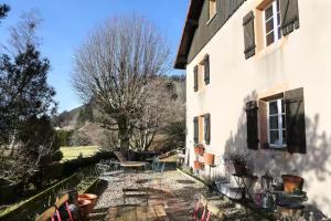 a patio with a table and chairs next to a building at Gite - Le befoigneu in Ramonchamp