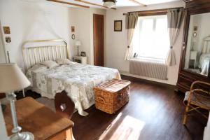 a bedroom with a bed and a window and a table at Gite - Le befoigneu in Ramonchamp