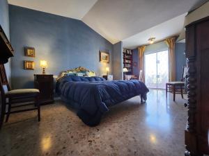 a bedroom with a large bed with blue walls at Argentario Rooms - By The Sea in Porto Santo Stefano