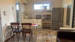 a kitchen with a table and two chairs and a refrigerator at Mains Rd 带厨房卫浴泳池附属公寓M4 in Brisbane