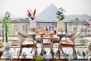 a table with food on top of a balcony at Legend Pyramids Inn Hostel in Cairo