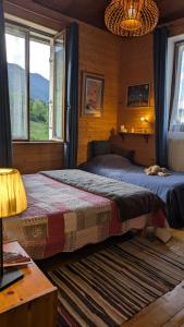ein Schlafzimmer mit zwei Betten in einer Blockhütte in der Unterkunft Une maison chaleureuse et accueillante au cœur de la Chartreuse in Saint-Pierre-dʼEntremont + 27 Fotos