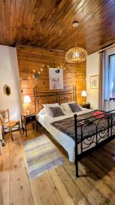 ein Schlafzimmer mit einem Bett und einer Holzwand in der Unterkunft Une maison chaleureuse et accueillante au cœur de la Chartreuse in Saint-Pierre-dʼEntremont