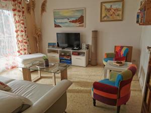 a living room with a couch and a table at Appartement dans villa avec jardin et piscine privée in Marguerittes