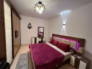 a bedroom with a large bed with a purple blanket at شقه المتحف in Ghaţāţī