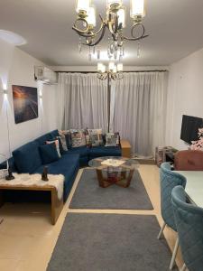 a living room with a blue couch and a table at شقه المتحف in Ghaţāţī