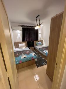 a bedroom with two beds in a room with a window at شقه المتحف in Ghaţāţī +2 photos