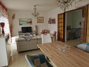 a living room with a table and a couch at Appartement dans villa avec jardin et piscine privée in Marguerittes