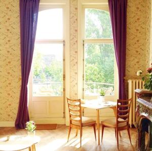 een eetkamer met een tafel en stoelen en een raam bij Maison Flagey Brussels in Brussel