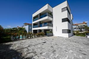 un condominio bianco con vialetto di Chesa Blue Apartment a Rovigno (Rovinj)