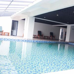 a swimming pool with two chairs in a building at Cozy Top-Floor Apartment with Balcony & City Views near United Nations Office in Ruaka