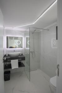a white bathroom with a sink and a shower at Casa da Mãe in Santana