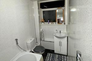 2 Bedroom Apartment - Sleeps 4 Free Parking Wifi في Pollokshaws: حمام صغير مع مرحاض ومغسلة