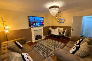 2 Bedroom Apartment - Sleeps 4 Free Parking Wifi في Pollokshaws: غرفة معيشة مع أريكتين وتلفزيون