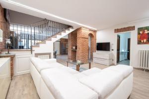 a living room with a white couch and a television at Casa a Roddi con vista sulle Colline in Roddi