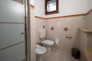 a bathroom with a toilet and a sink and a mirror at Casa a Roddi con vista sulle Colline in Roddi +12 photos