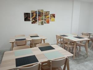 a classroom with tables and chairs and a painting on the wall at Habitaciones Algodón con baño propio in Palencia