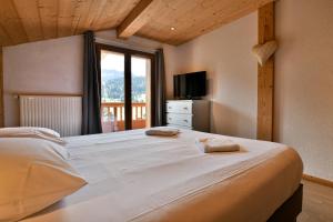 Un dormitorio con una cama grande y una ventana. en Chalet Anou - proche pistes de ski, en Le Chinaillon