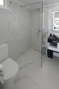 a white bathroom with a shower and a toilet at Casa da Mãe in Santana +35 photos