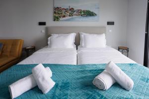 a bedroom with two beds with towels on the bed at Casa da Mãe in Santana