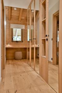 Habitación con paredes de madera y espejo. en Chalet Chinaille A1, en Le Chinaillon