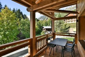 Una terraza de madera con una mesa y sillas. en Chalet Chinaille A1, en Le Chinaillon