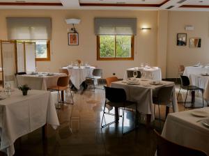 a dining room with tables and chairs with white tablecloths at Hotel Eibar in Éibar