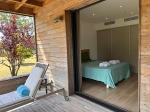 Zimmer mit einem Bett, einem Stuhl und einem Spiegel in der Unterkunft Pineto, villa 3 chambres au coeur de la pinède in Biguglia