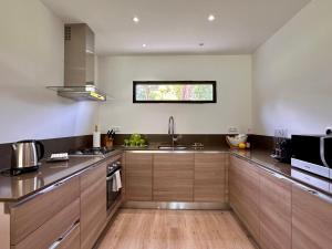 eine große Küche mit Holzschränken und einem Waschbecken in der Unterkunft Pineto, villa 3 chambres au coeur de la pinède in Biguglia