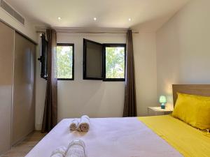 ein Schlafzimmer mit einem Bett mit zwei Hausschuhen darauf in der Unterkunft Pineto, villa 3 chambres au coeur de la pinède in Biguglia