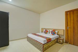 Un dormitorio con una cama y una puerta de madera. en Via Square Inn, en Bhopal 20 fotos más