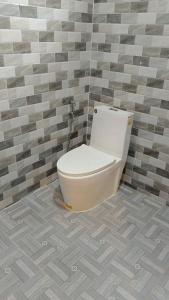 La salle de bains est pourvue de toilettes et d'un mur carrelé. dans l'établissement ណាវិតាយ៉ារី បឹងហ្គាឡូ Navitayary Bungalow, à Krong Saen Monourom