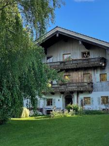 a large wooden house with a balcony on it at ChiemseeRefugium - Ferienwohnung Berg in Bernau am Chiemsee