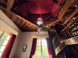 een kamer met een rood plafond en een kroonluchter bij Manoir et Appartements avec piscine au Domaine de Bize Mirepoix in Mirepoix