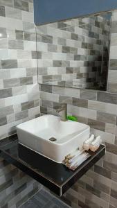 une salle de bain avec un lavabo et un miroir dans l'établissement ណាវិតាយ៉ារី បឹងហ្គាឡូ Navitayary Bungalow, à Krong Saen Monourom